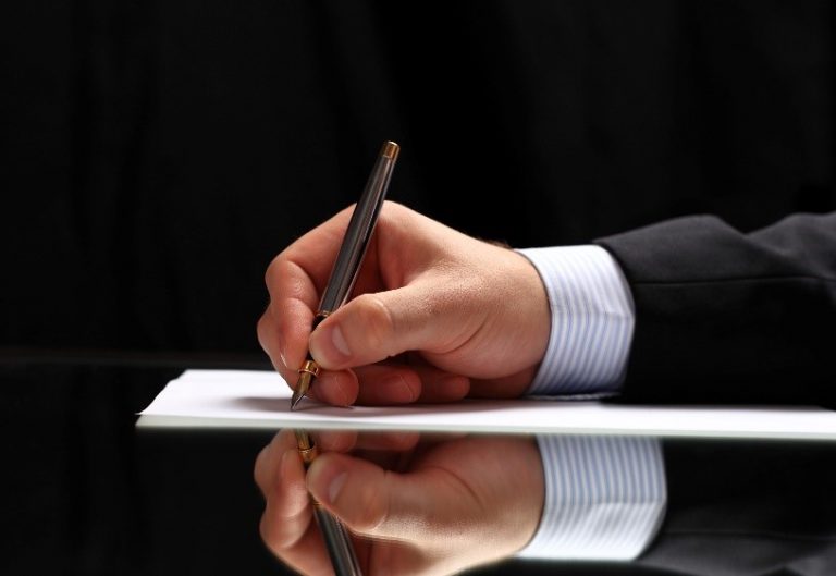 man's hand shown writing