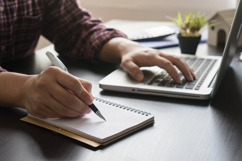 man-writing-in-notebook